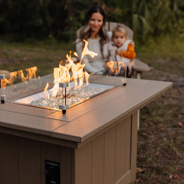 Mom sitting with child in front of a fire table